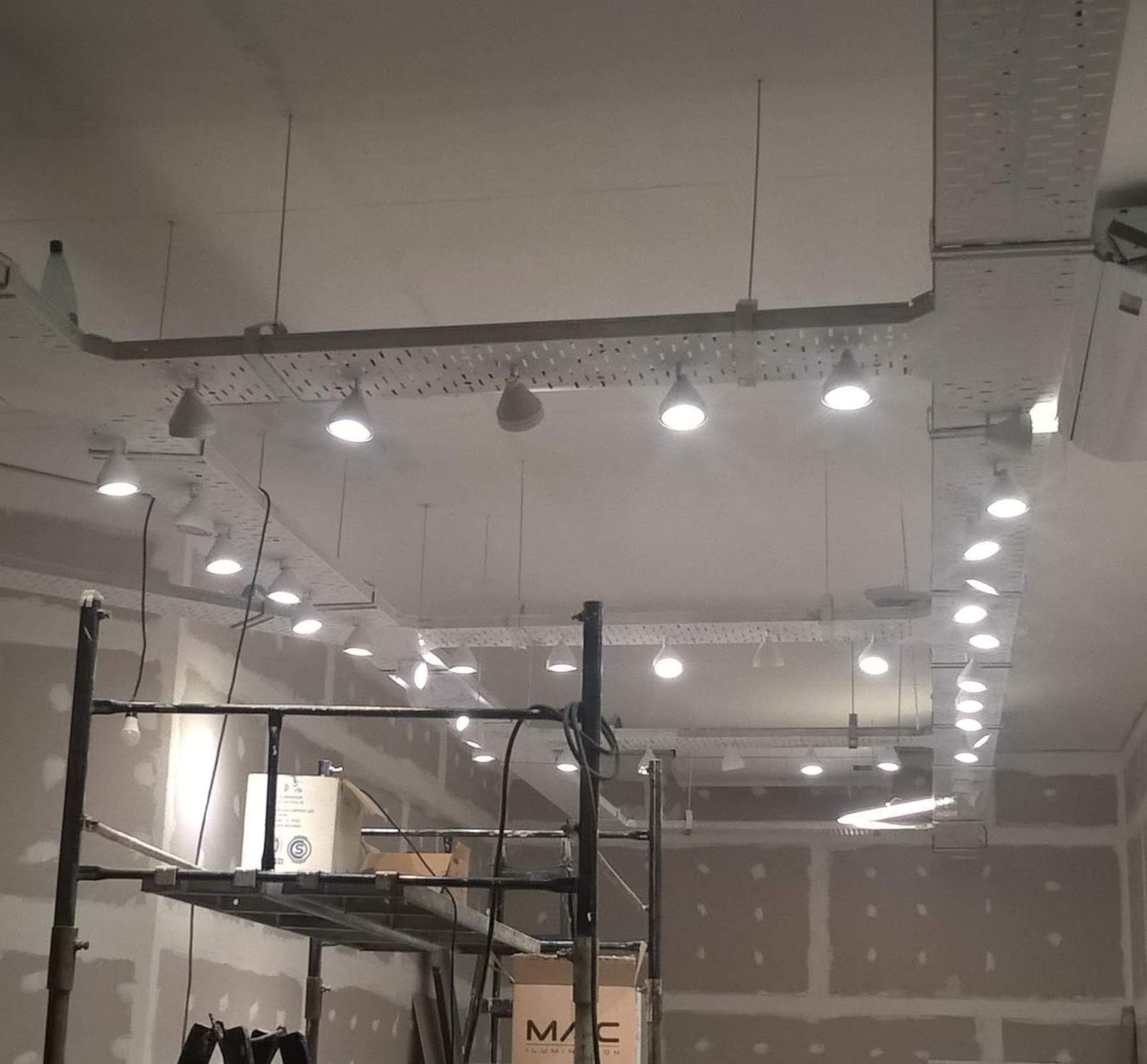 Cielorraso con luminarias empotradas encendidas en local comercial