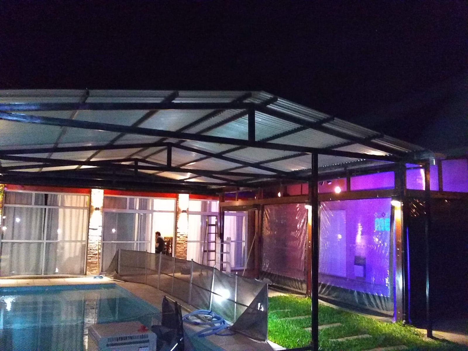 Estructura metálica con techo traslúcido iluminada de noche