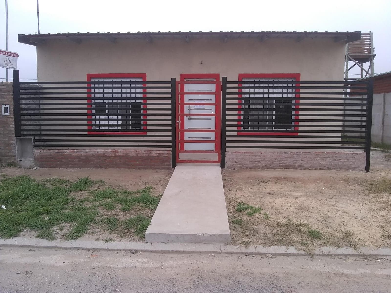 Frente de casa con rejas y portón de herrería terminados