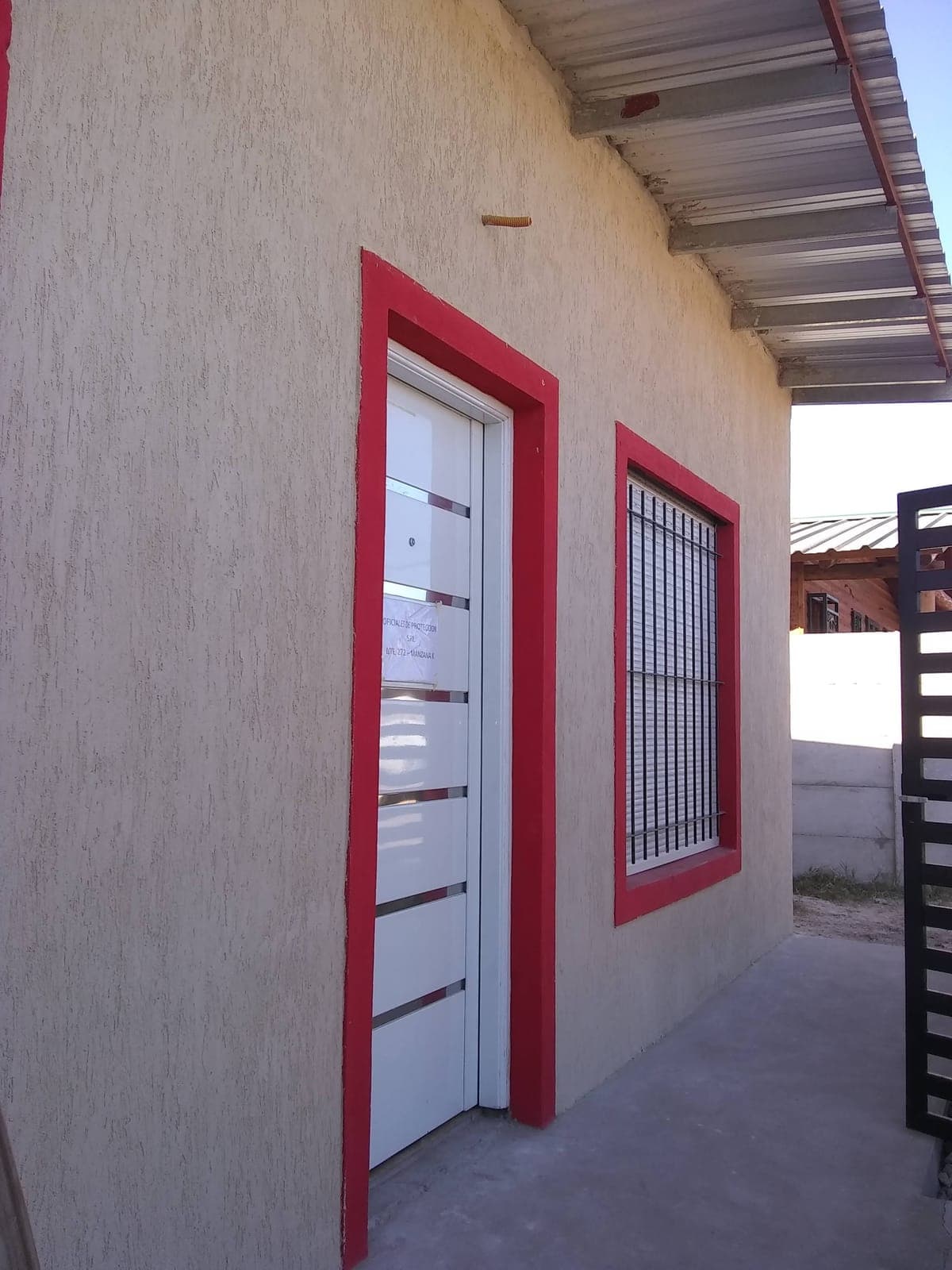 Frente de casa con aberturas recién pintadas en rojo
